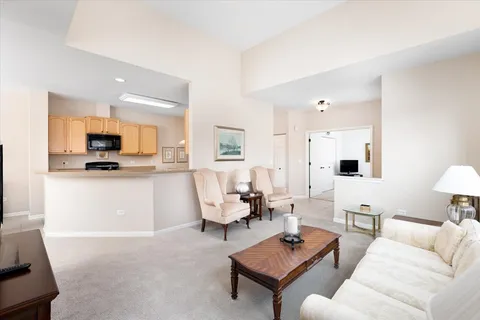 a living room with furniture and view of kitchen