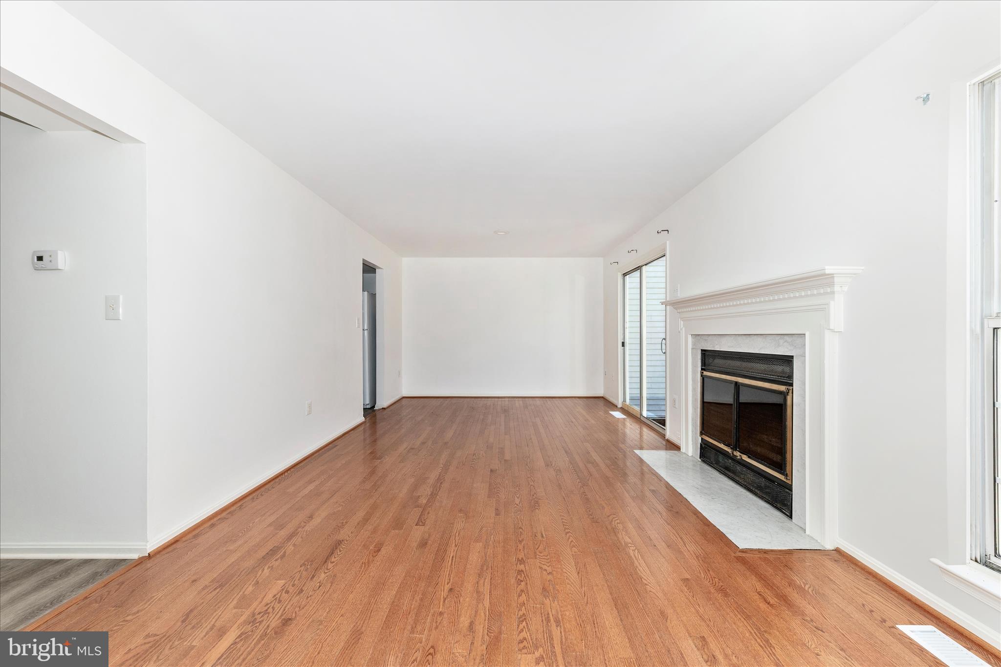 13303 Country Ridge Drive Germantown, MD 20874 - Photo 15 of 45 an empty room with wooden floor fireplace and windows