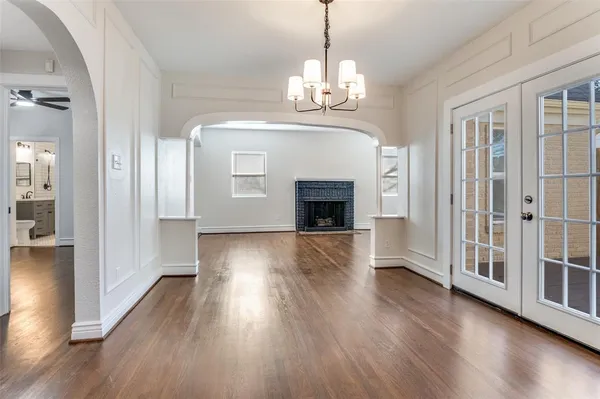 a view of a livingroom with wooden floor fireplace and a window