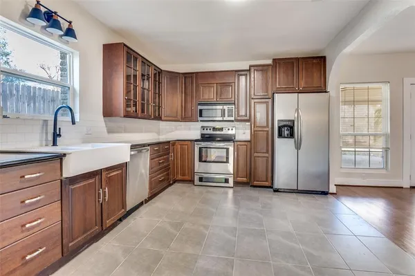 a kitchen with stainless steel appliances a refrigerator sink and cabinets
