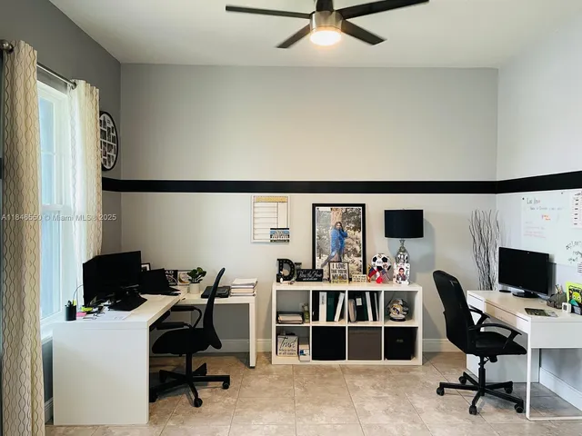 a view of a workspace with furniture and a window