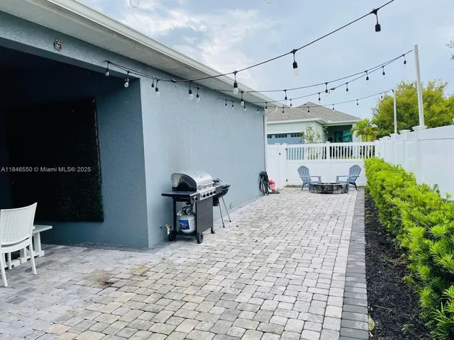 a view of a patio with table and chairs a barbeque