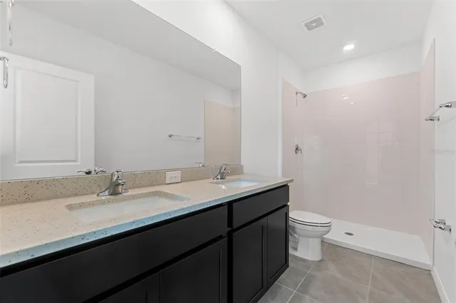 a bathroom with a granite countertop sink a toilet and a mirror