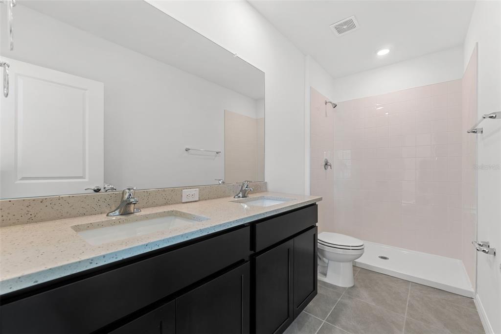 31336 Paper Birch Street Wesley Chapel, FL 33545 - Photo 14 of 38 a bathroom with a granite countertop sink a toilet and a mirror