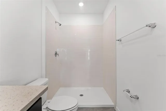 a bathroom with a granite countertop sink toilet and shower