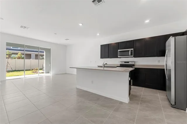 a kitchen with a refrigerator and a stove top oven
