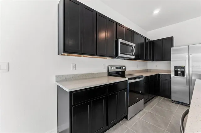 a kitchen with stainless steel appliances a stove microwave and sink