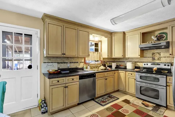 a kitchen with stainless steel appliances granite countertop a stove sink and cabinets