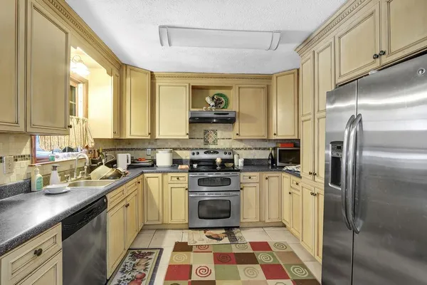 a kitchen with a sink a refrigerator and cabinets
