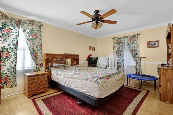 a bedroom with a bed a dresser next to a window