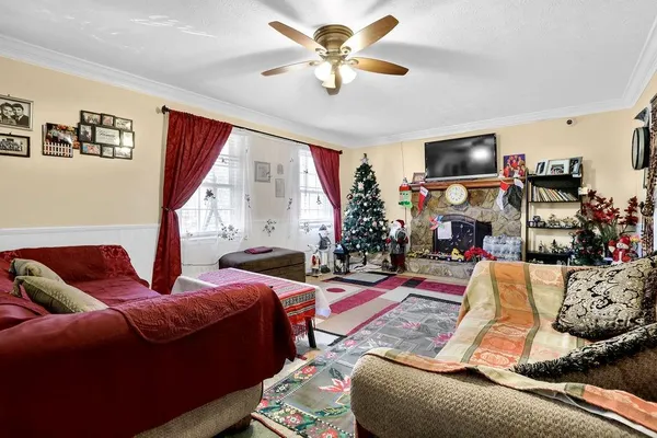 a living room with furniture a flat screen tv and a large window