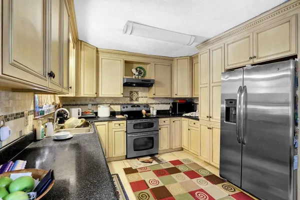 a kitchen with a sink a refrigerator and a stove top oven