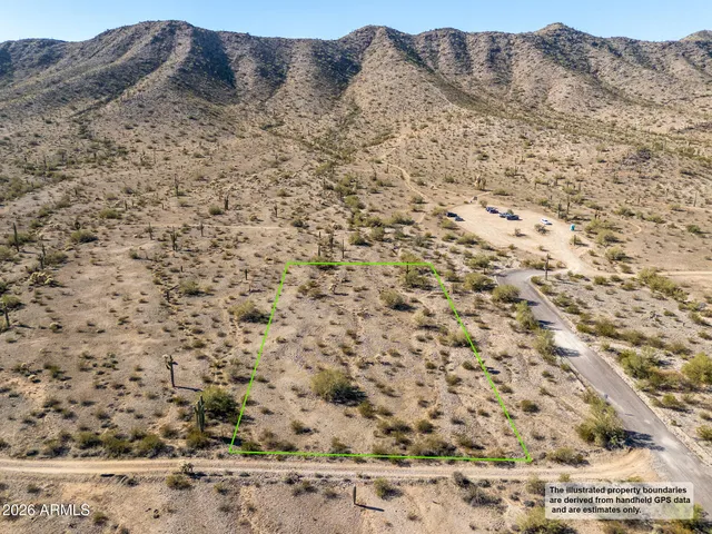 a view of a dry yard with mountains in the background