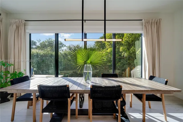 a large kitchen with kitchen island a large window a sink and stainless steel appliances