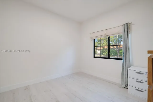 an aerial view of residential house with outdoor space and trees all around