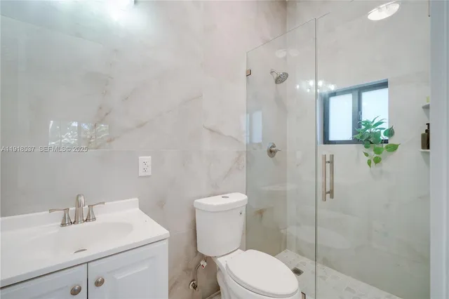 an aerial view of residential houses with outdoor space and trees