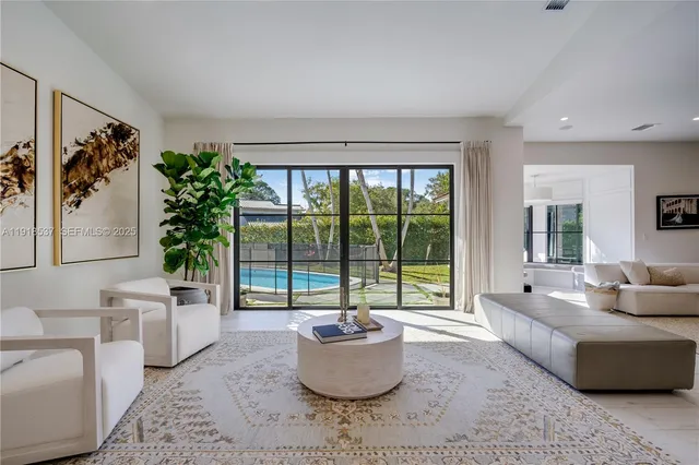 a living room with a large window and a chandelier