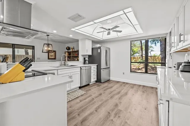 a view of a kitchen with cabinets and wooden floor