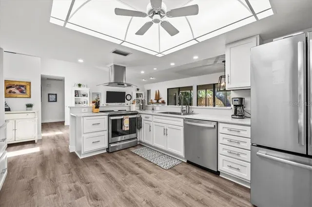 a kitchen with white cabinets and stainless steel appliances