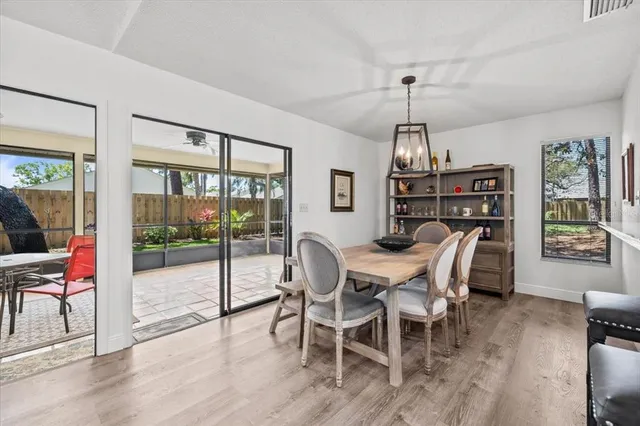 a dining room with furniture a chandelier and wooden floor