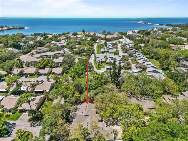 an aerial view of ocean and residential houses with outdoor space