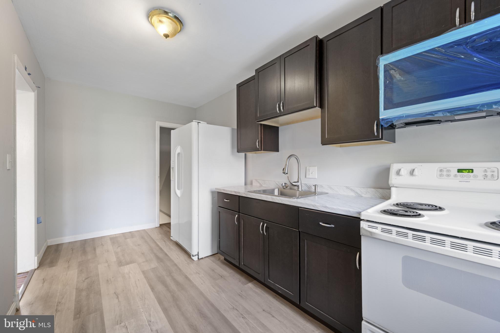 1516 East 36th Street Baltimore, MD 21218 - Photo 11 of 33 a kitchen with a sink a stove and cabinets