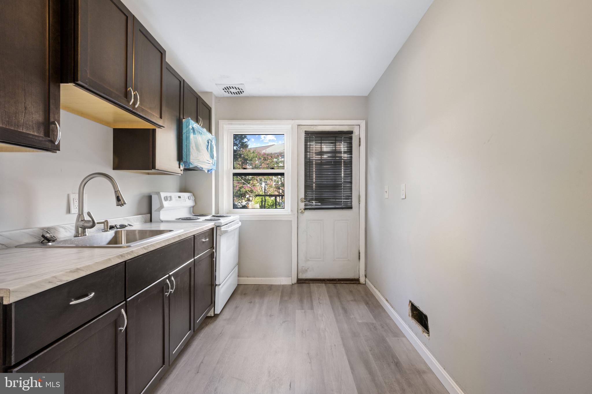 1516 East 36th Street Baltimore, MD 21218 - Photo 12 of 33 a kitchen with a sink cabinets and window