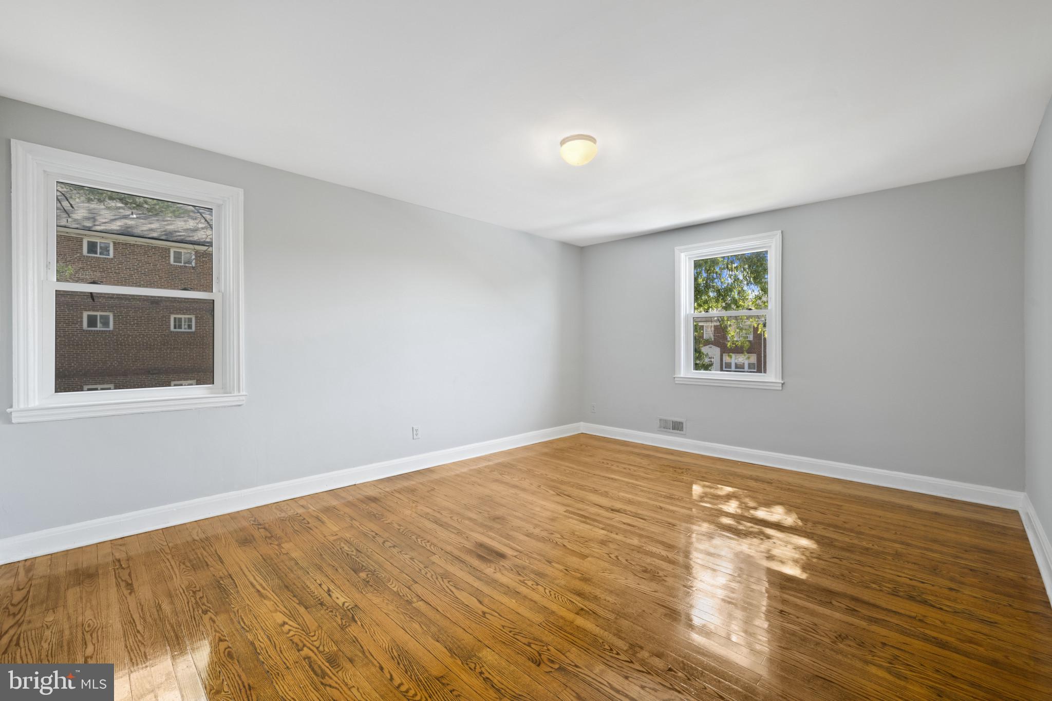 1516 East 36th Street Baltimore, MD 21218 - Photo 14 of 33 a view of an empty room with window and wooden floor