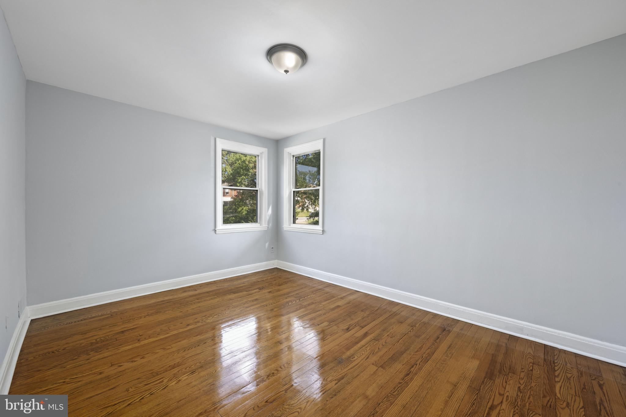 1516 East 36th Street Baltimore, MD 21218 - Photo 16 of 33 a view of an empty room with wooden floor and a window