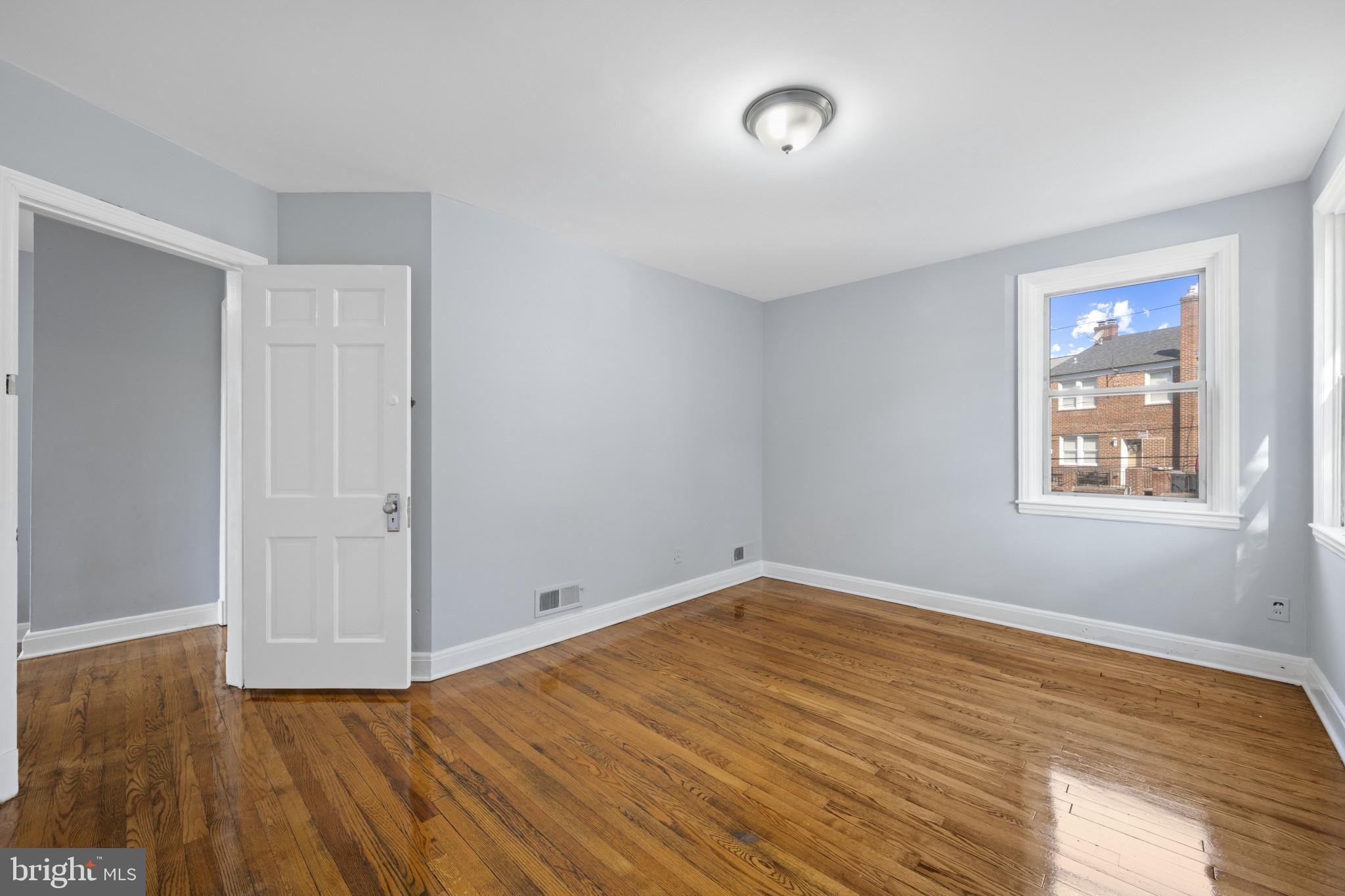 1516 East 36th Street Baltimore, MD 21218 - Photo 17 of 33 an empty room with wooden floor and windows