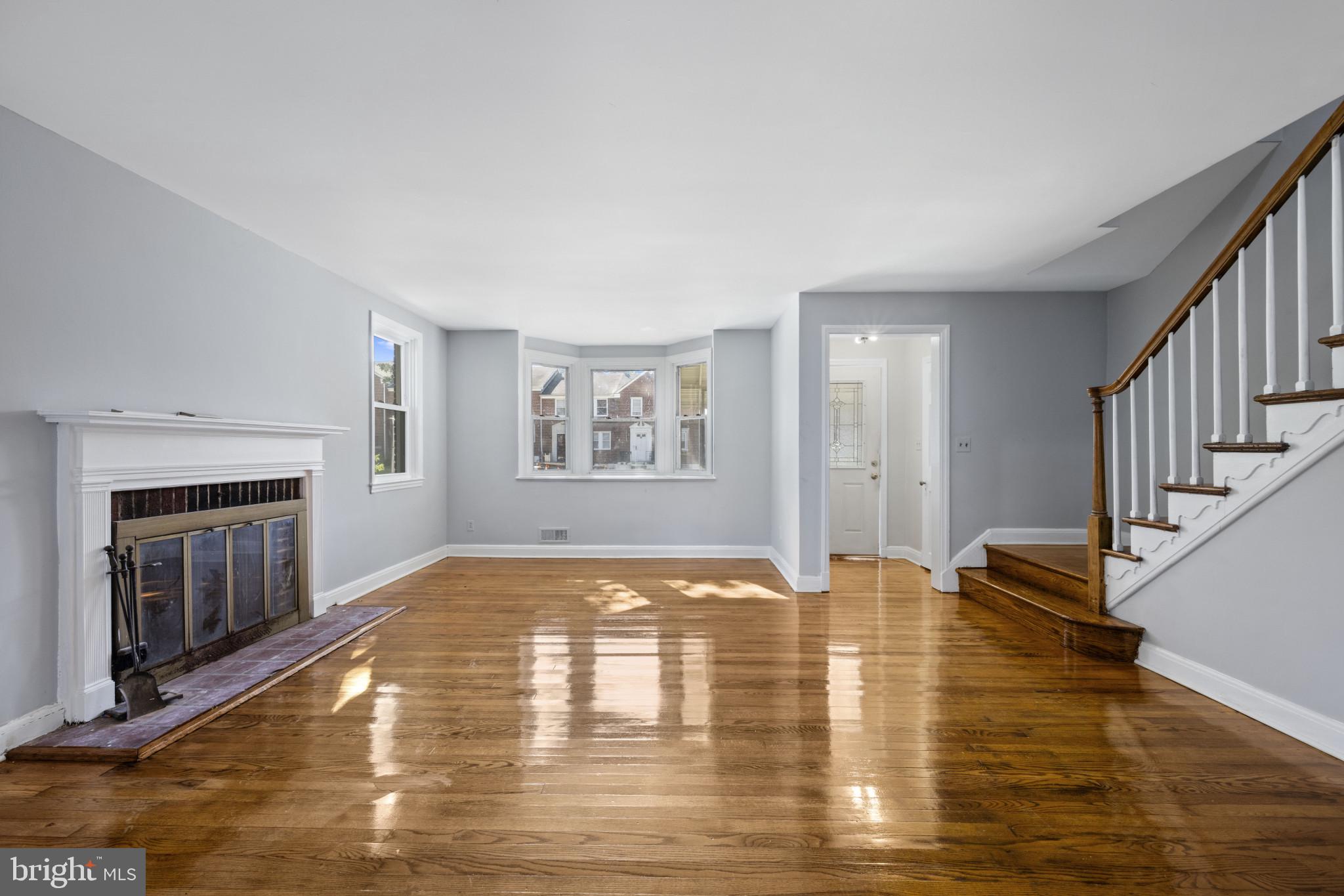 1516 East 36th Street Baltimore, MD 21218 - Photo 2 of 33 a view of empty room with fireplace and wooden floor