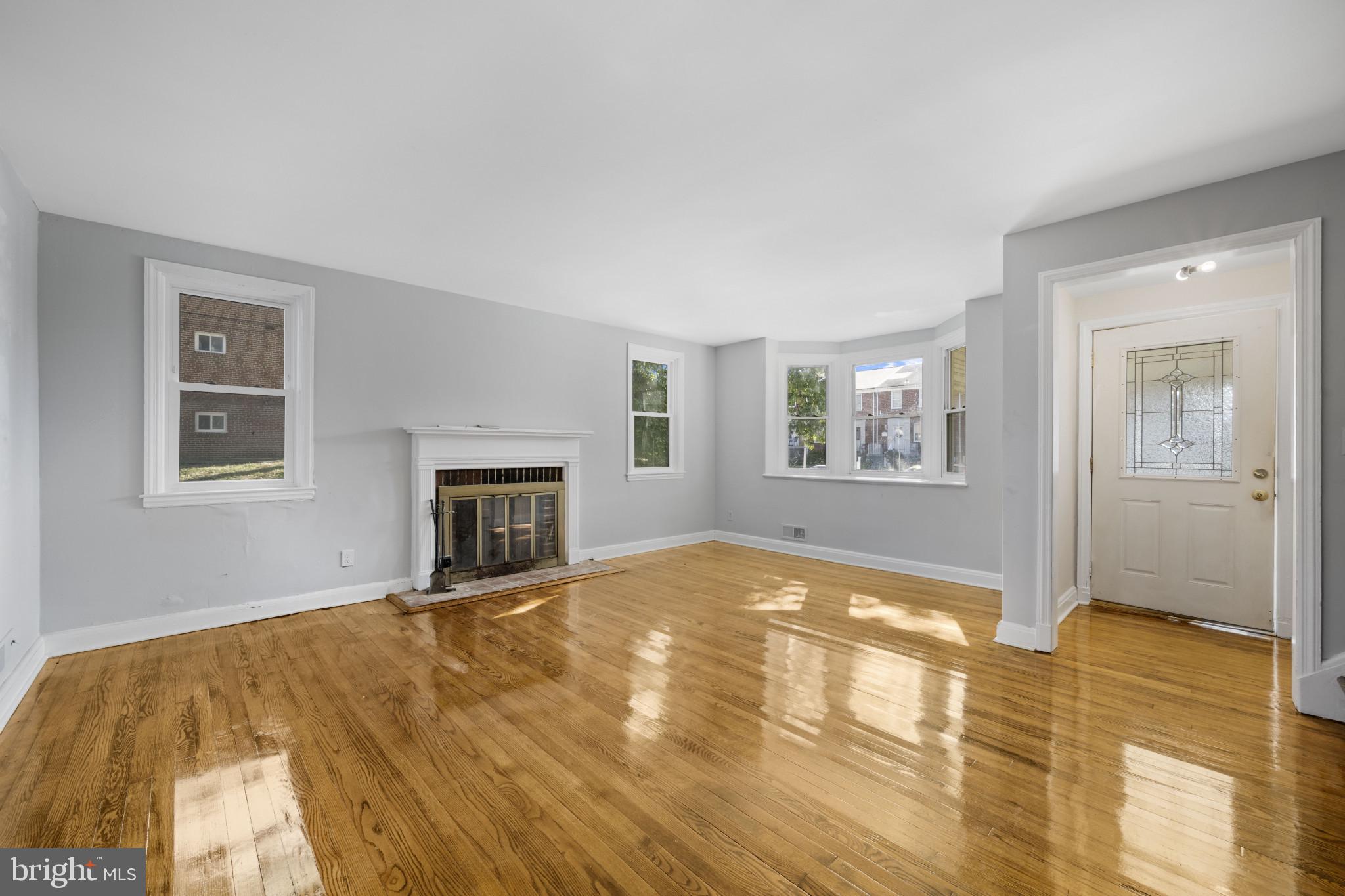 1516 East 36th Street Baltimore, MD 21218 - Photo 4 of 33 a view of empty room with wooden floor and fireplace