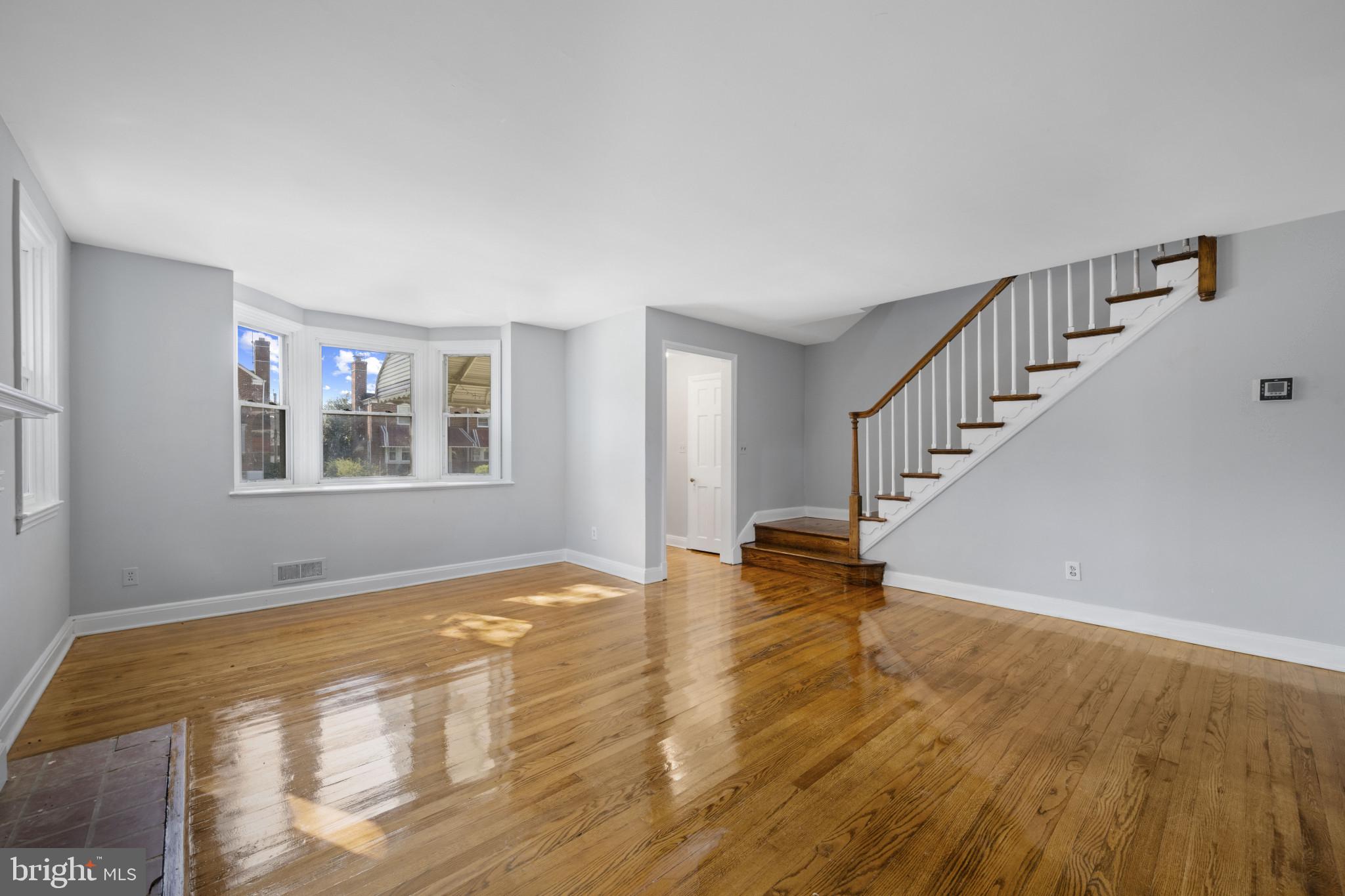 1516 East 36th Street Baltimore, MD 21218 - Photo 5 of 33 a view of an empty room with wooden floor and a window