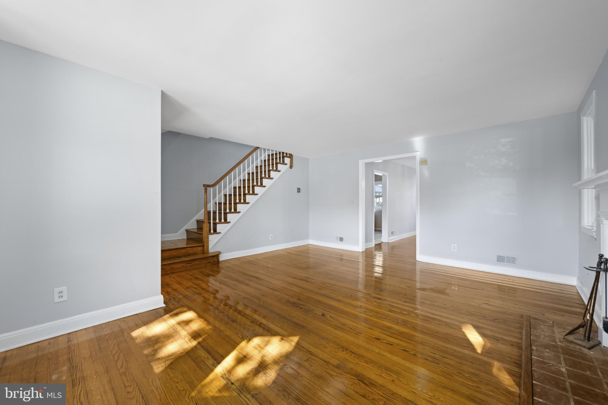 1516 East 36th Street Baltimore, MD 21218 - Photo 6 of 33 a view of an empty room with wooden floor and stairs