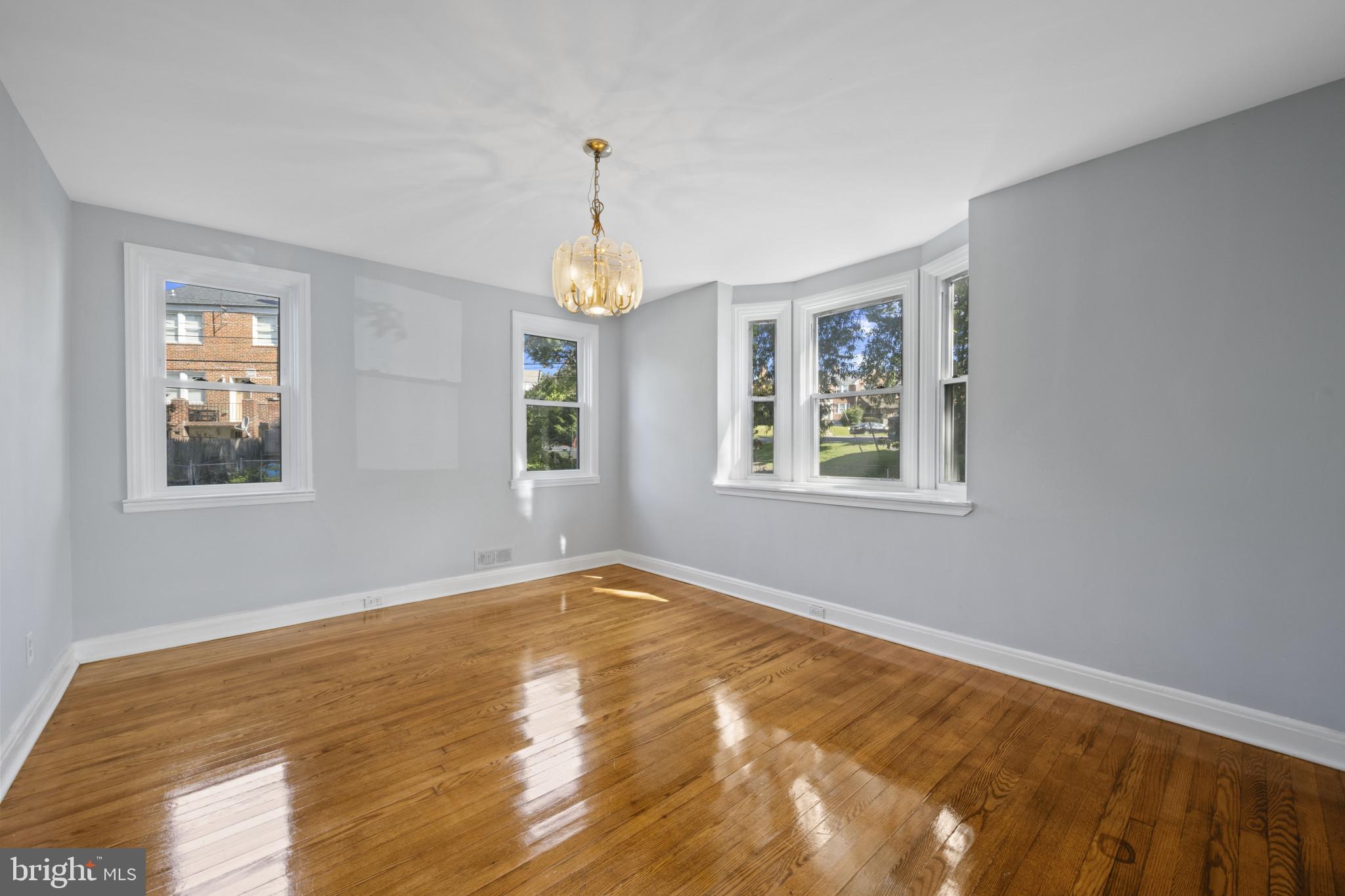 1516 East 36th Street Baltimore, MD 21218 - Photo 7 of 33 a view of an empty room with window and wooden floor