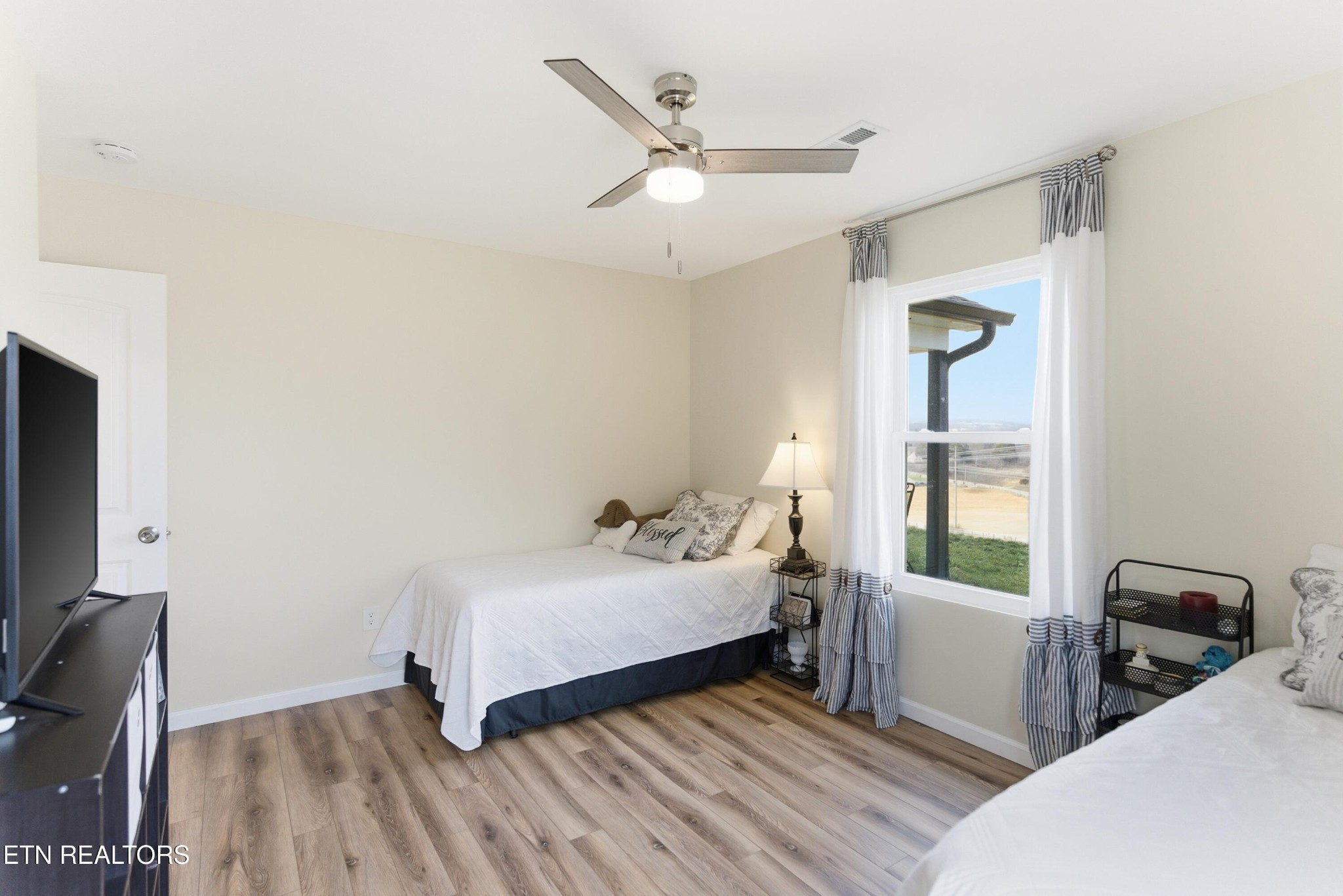 6911 Fairview Road Corryton, TN 37721 - Photo 19 of 30 a bedroom with a bed a window and a flat screen tv