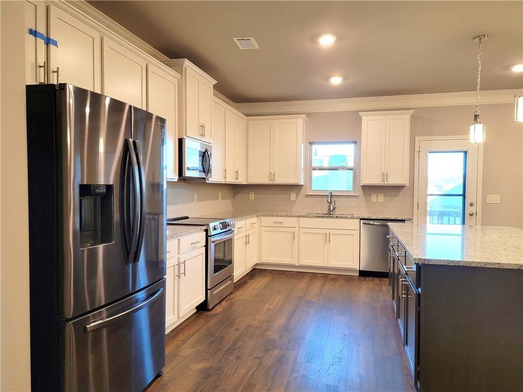 1866 Castleberry Drive Buford, GA 30518 - Photo 5 of 11 a kitchen with stainless steel appliances a refrigerator sink and cabinets