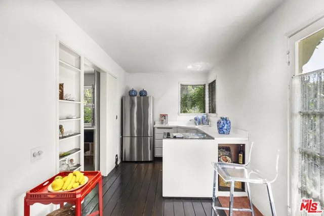 a view of a kitchen with fridge and workspace