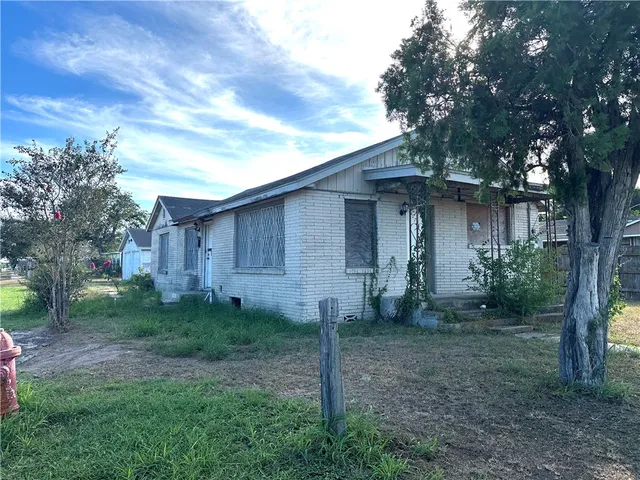 a view of a house with backyard and trees