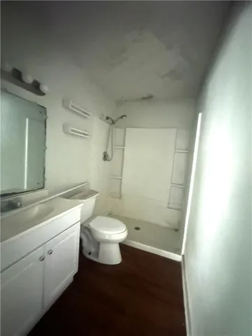 a bathroom with a toilet sink a shower and vanity