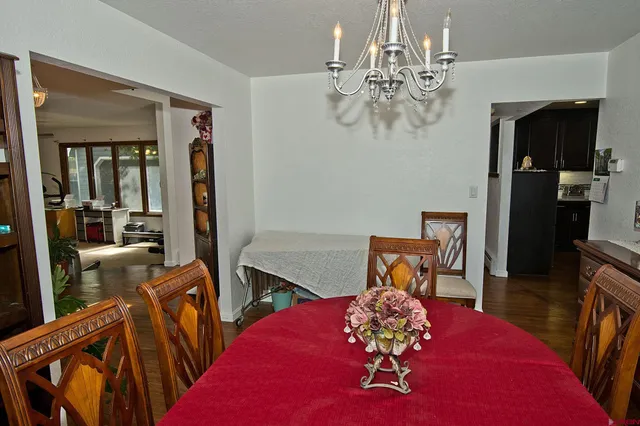 a view of a dining room with furniture a chandelier and wooden floor