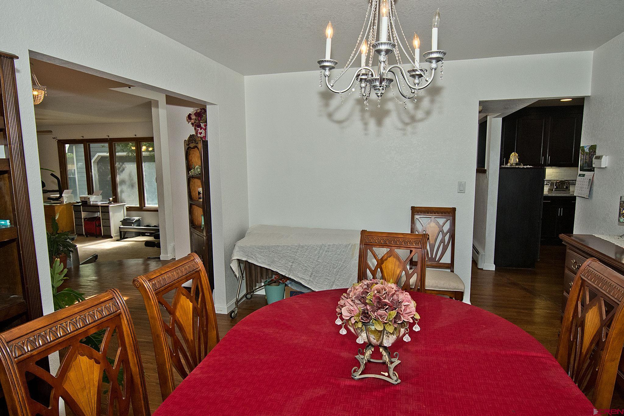808 Weber Drive Alamosa, CO 81101 - Photo 15 of 44 a view of a dining room with furniture a chandelier and wooden floor