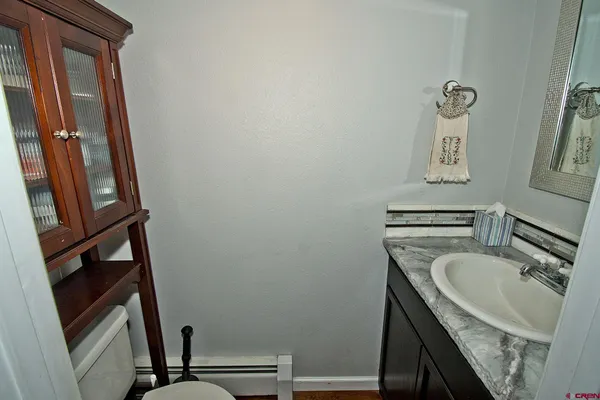 a bathroom with a sink a toilet and a mirror