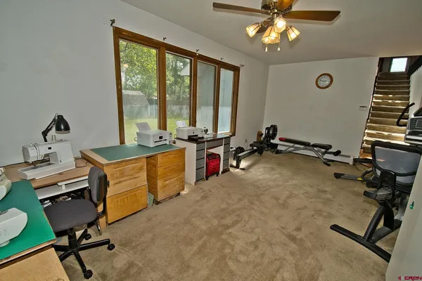 a view of a workspace with furniture and a window