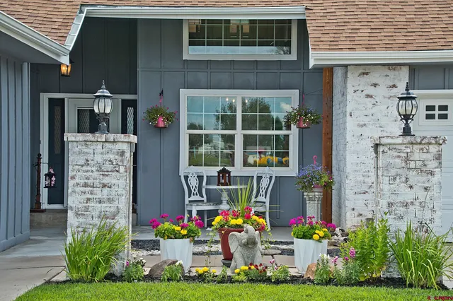 a front view of multi story residential apartment building with yard and flowers