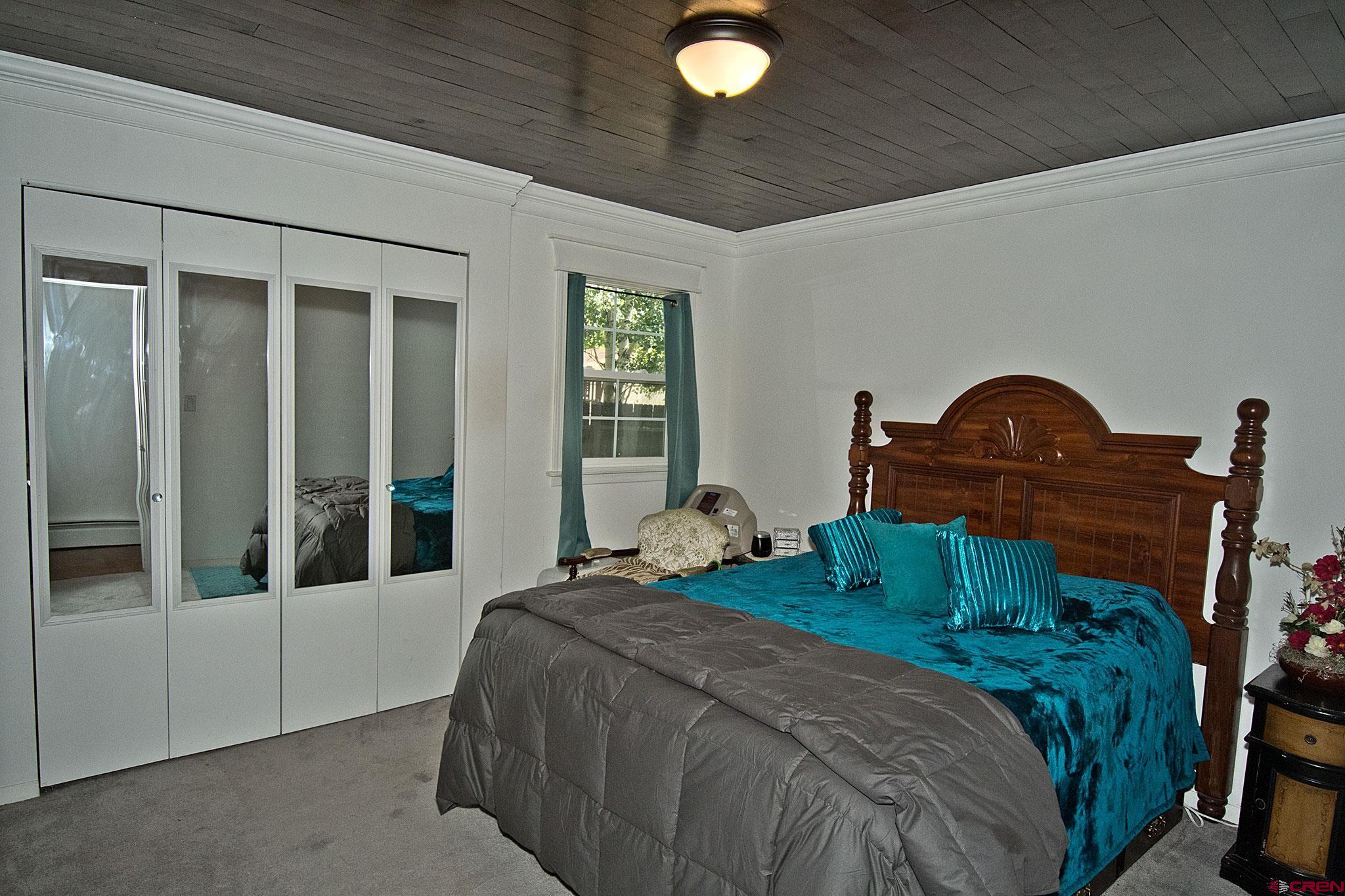 808 Weber Drive Alamosa, CO 81101 - Photo 22 of 44 a bedroom with a bed and a mirror