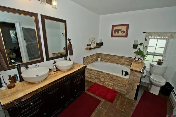a bathroom with a granite countertop sink mirror and tub