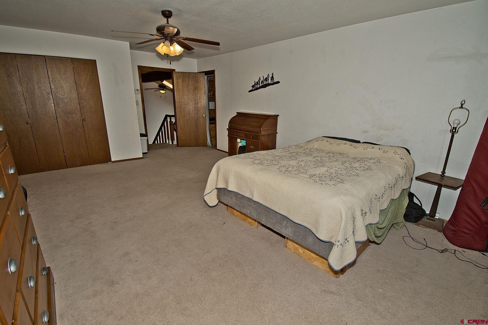 808 Weber Drive Alamosa, CO 81101 - Photo 30 of 44 a bedroom with a bed and a chandelier