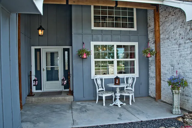 a patio with table and chairs and potted plants