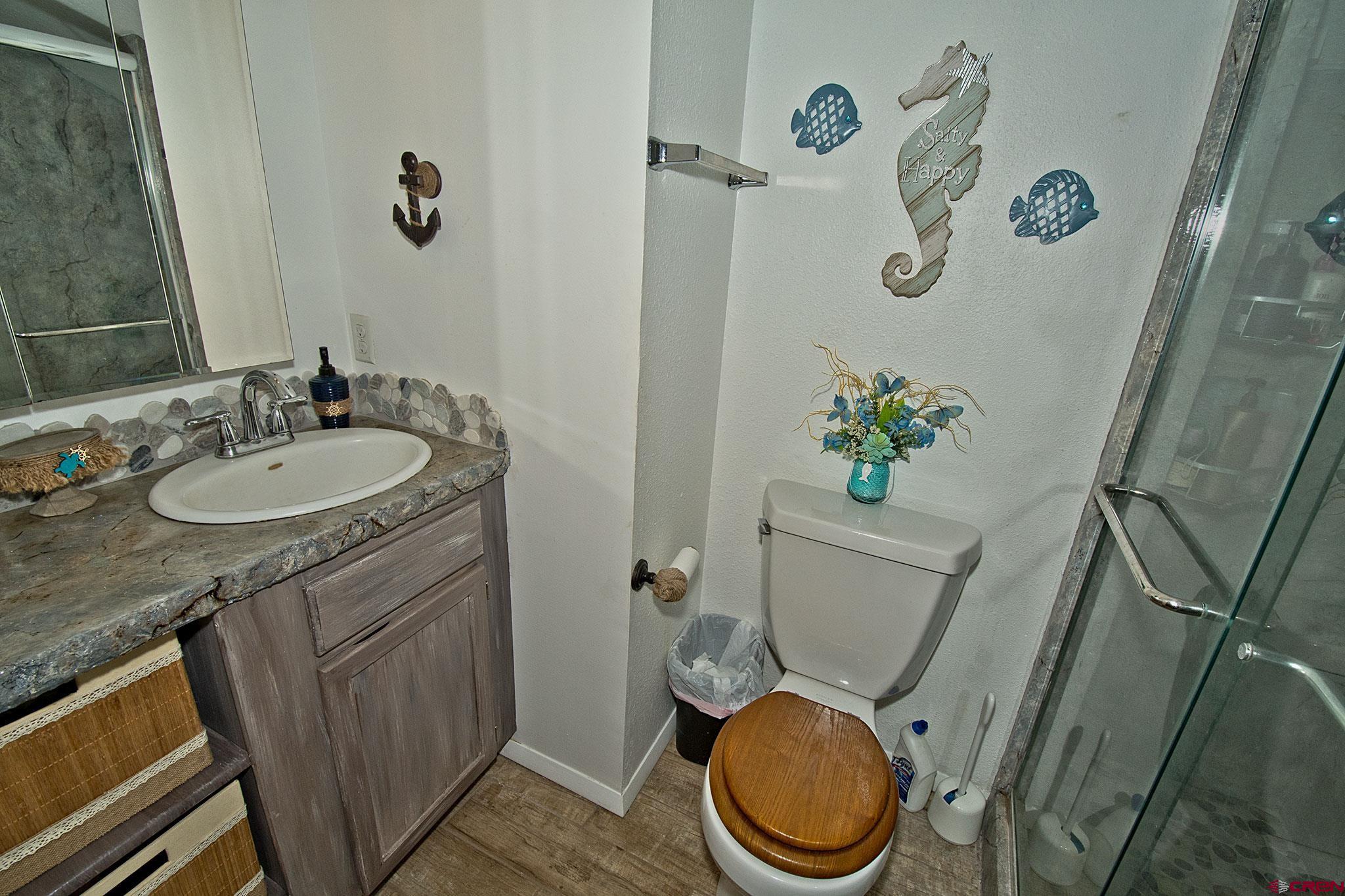 808 Weber Drive Alamosa, CO 81101 - Photo 31 of 44 a bathroom with a granite countertop sink toilet and a mirror